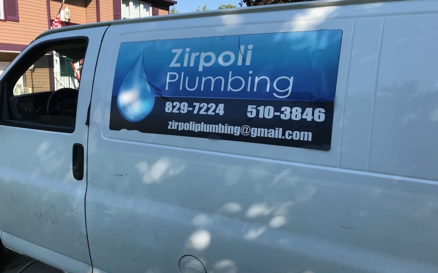 The Zirpoli Plumbing van, white with the blue water-drop decal, parked in a South Buffalo driveway